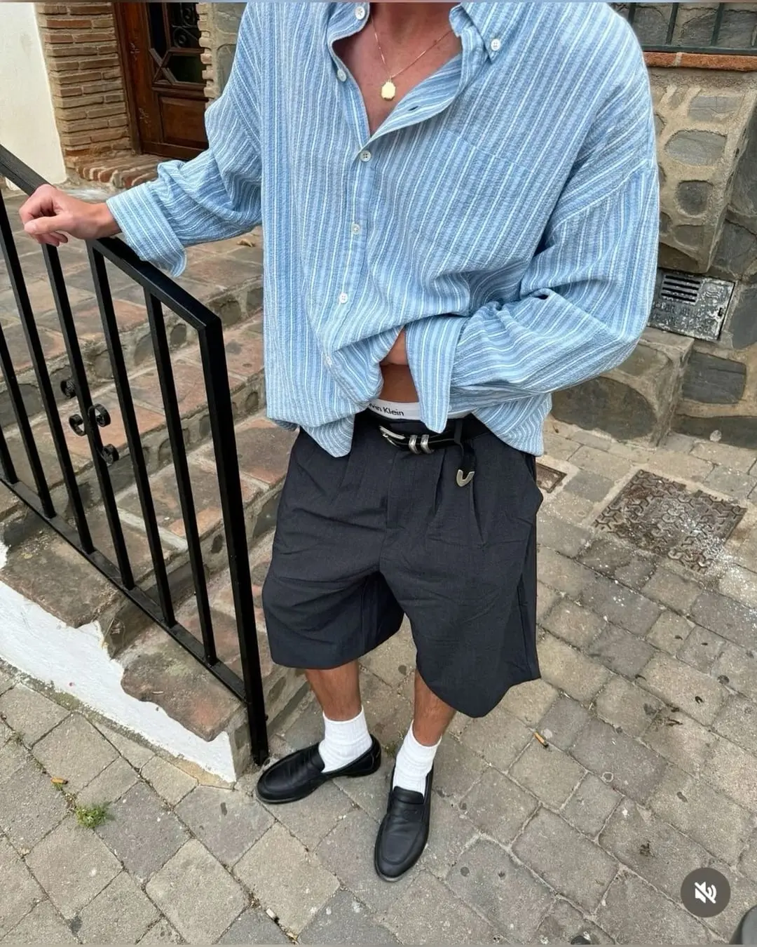 Outfits para Nochevieja (hombre): camisa de rayas azul oversize, bermudas grises anchas y mocasines con calcetín blanco