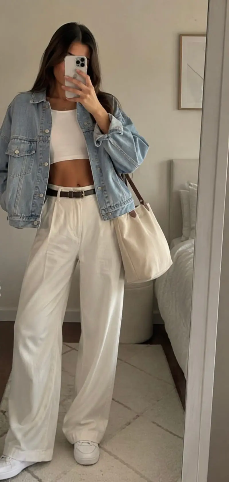 Outfit minimalist mujer: chaqueta vaquera, top blanco corto y pantalón ancho blanco